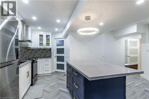 Kitchen featuring a central island with a light-colored countertop and dark blue cabinetry - 252 Thorner Drive Unit# Basement, Hamilton, ON 