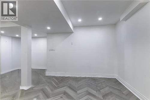Recessed lighting illuminates a spacious room featuring a combination of light gray flooring and herringbone wood-finish flooring, complemented by white walls and trim - 252 Thorner Drive Unit# Basement, Hamilton, ON 