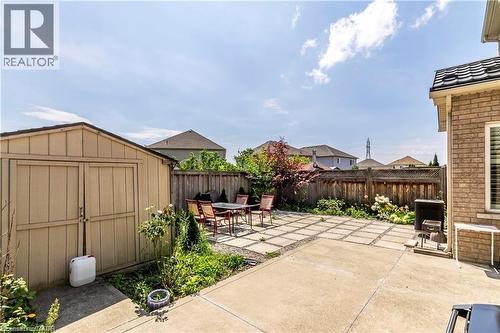 Expansive backyard featuring a concrete patio with inset paver stones, a wooden privacy fence, and a dedicated storage shed - 252 Thorner Drive Unit# Basement, Hamilton, ON 
