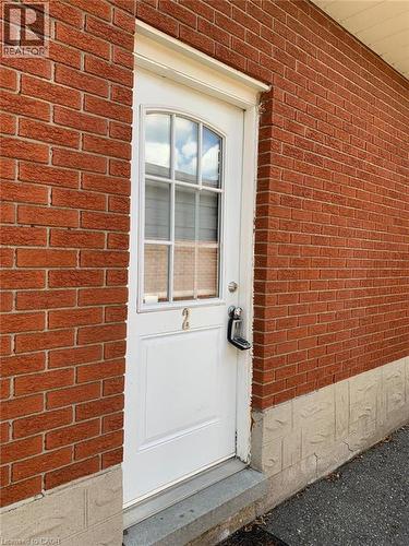 Red brick exterior with a white entry door featuring an arched window with grid detailing - 58 Farrier Drive Unit# Basement, Kitchener, ON - Outdoor With Exterior
