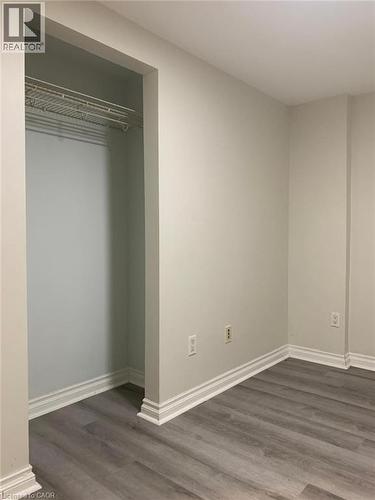 Kitchen featuring white cabinetry, gray and white tile backsplash, white appliances, and wood-finish flooring - 58 Farrier Drive Unit# Basement, Kitchener, ON - Indoor Photo Showing Other Room