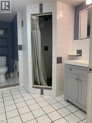 Bathroom featuring white square floor tiling and a corner shower stall with a rain shower head - 58 Farrier Drive Unit# Basement, Kitchener, ON - Indoor Photo Showing Bathroom