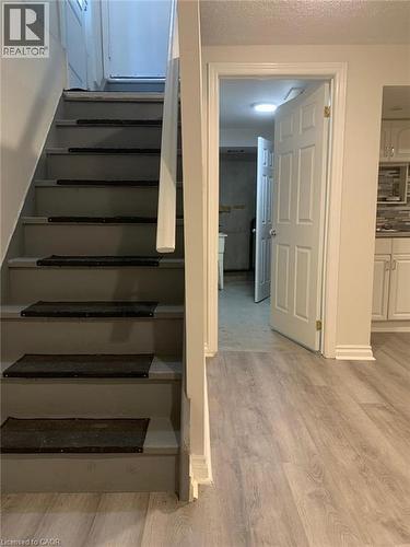 Staircase with light gray treads and white risers, featuring a white painted handrail - 58 Farrier Drive Unit# Basement, Kitchener, ON - Indoor Photo Showing Other Room
