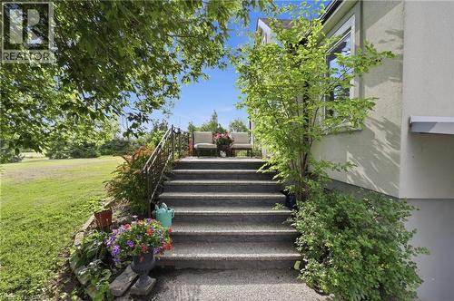 Exterior staircase with a wrought iron railing, leading to a raised porch - 97 Smith Road, Hamilton, ON 