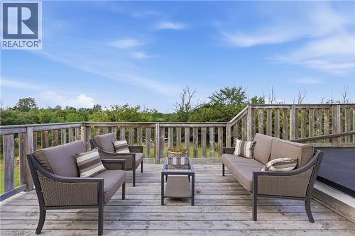 Expansive wooden deck featuring horizontal railings, ample outdoor space, and a clear sky backdrop - 97 Smith Road, Hamilton, ON 