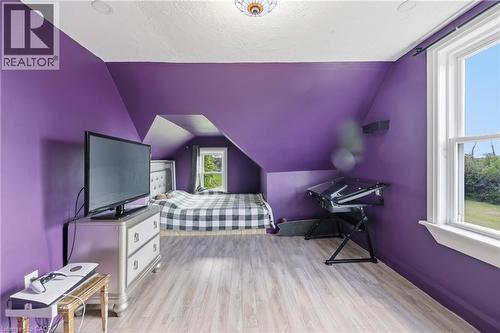 Room featuring sloped ceilings, light wood-finish flooring, recessed lighting, and a double-hung window - 97 Smith Road, Hamilton, ON 