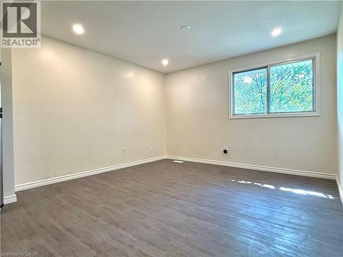 Bright interior space featuring wood-finish flooring, recessed lighting, and a white trim baseboard - 62 Bond Street Unit# 3, Kitchener, ON - Indoor Photo Showing Other Room