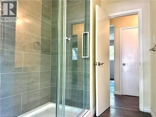 Glass-enclosed shower with large format tile surround and white shower pan - 62 Bond Street Unit# 3, Kitchener, ON - Indoor Photo Showing Bathroom
