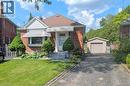 Brick exterior featuring a front lawn, bay window with awning, concrete front steps, a paved driveway, and a detached garage - 98 Kipling Road Unit# 2, Hamilton, ON 