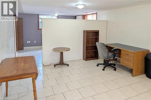 Spacious tiled flooring area featuring a partial room divider, recessed lighting, and a distinct separate room entrance - 98 Kipling Road Unit# 2, Hamilton, ON 