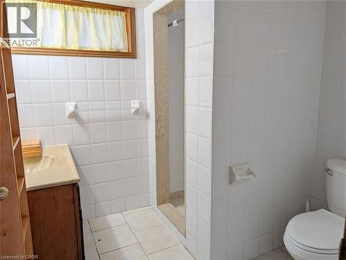 Bathroom featuring white square wall tiles and coordinating floor tiles - 98 Kipling Road Unit# 2, Hamilton, ON 