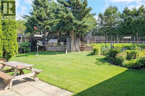 Spacious backyard featuring a manicured lawn, established garden beds, and mature trees providing natural screening - 98 Kipling Road Unit# 2, Hamilton, ON 
