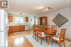 Kitchen and dining area featuring wood-finish flooring, recessed lighting, track lighting, a window over the sink, and a glass-paneled door - 