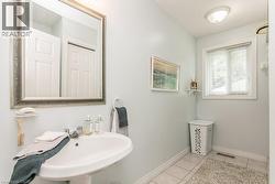 Pedestal sink with chrome fixtures and an ornate framed mirror - 