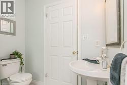 Pedestal sink with white ceramic basin, paneled interior door, and light wall paint - 