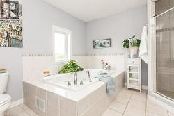 Built-in soaking tub with chrome fixtures and surrounding tilework - 