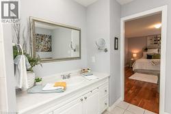 Vanity with an integrated sink, white cabinetry, and a framed mirror - 