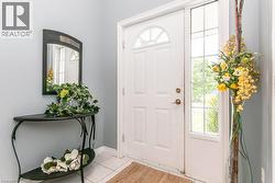 Entryway featuring a paneled front door with an arched transom window and a full-length sidelight - 
