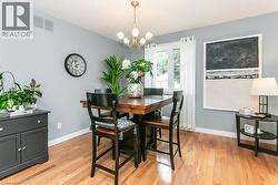 Hardwood flooring throughout this dining space, featuring light gray walls and white trim - 