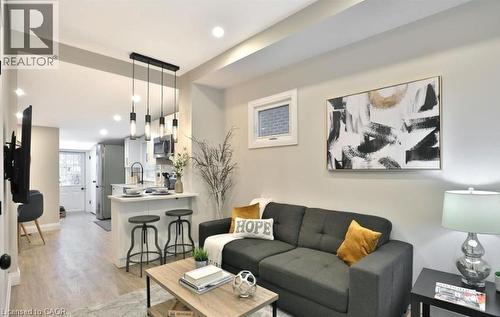 Open-concept living space featuring wood-finish flooring and recessed lighting - 33 Hawthorne Avenue, Hamilton, ON 