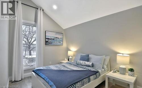 Bedroom featuring a vaulted ceiling, large window, recessed lighting, and light wood-finish flooring - 33 Hawthorne Avenue, Hamilton, ON 