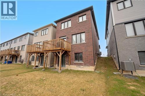 Brick and siding exterior featuring multiple windows and a wooden deck - 61 Vanilla Trail, Thorold, ON 