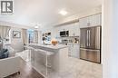 Modern kitchen featuring light cabinetry, stainless steel appliances, and a central island with a stone countertop - 61 Vanilla Trail, Thorold, ON 