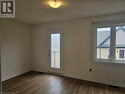 Empty room with a textured ceiling and dark wood finished floors - 