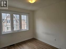 Empty room featuring dark wood-style flooring and a textured ceiling - 