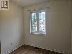 Spare room with baseboards and dark wood-type flooring - 