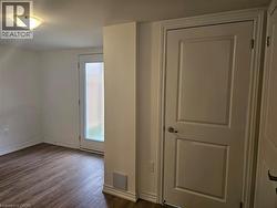 Unfurnished room featuring baseboards and dark wood-type flooring - 
