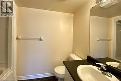 Bathroom featuring a vanity with an integrated sink, polished chrome faucet, and a wall-mounted mirror - 