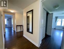 Hallway featuring dark wood-finish flooring, white baseboards - 