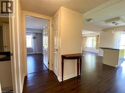 Hardwood-finish flooring extends throughout this interior, featuring light-toned walls and white trim - 