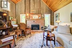 Vaulted wood-paneled ceilings over a brick fireplace with a black firebox - 