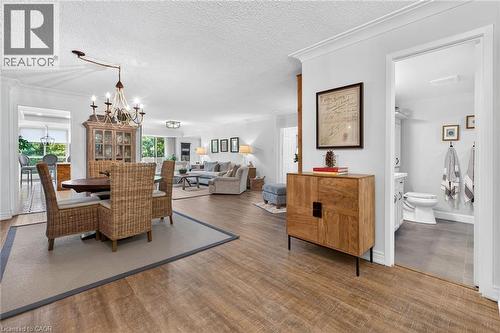 Open-concept interior featuring wood-finish flooring, recessed lighting, crown molding, and a chandelier - 1237 North Shore Boulevard Unit# 405, Burlington, ON - Indoor