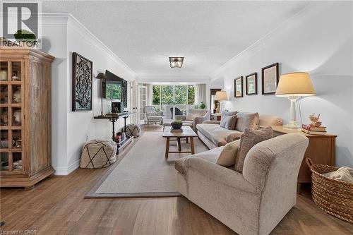Open concept living space featuring wood-finish flooring and crown molding - 1237 North Shore Boulevard Unit# 405, Burlington, ON - Indoor Photo Showing Living Room