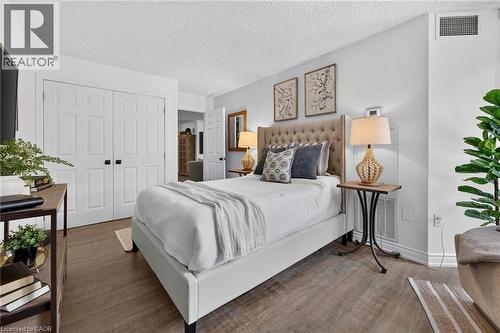 Bedroom featuring wood-finish flooring, light grey walls, and white baseboards - 1237 North Shore Boulevard Unit# 405, Burlington, ON - Indoor Photo Showing Bedroom
