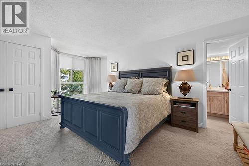 Spacious bedroom featuring carpeted flooring and white walls - 1237 North Shore Boulevard Unit# 405, Burlington, ON - Indoor Photo Showing Bedroom