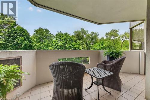 Outdoor balcony featuring light-toned tile flooring and a solid perimeter wall - 1237 North Shore Boulevard Unit# 405, Burlington, ON - Outdoor With Exterior