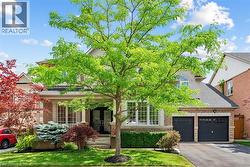 Stately two-story residence featuring a stone and stucco facade, a double-door entry, and a two-car garage - 