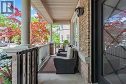 Covered front porch featuring large columns and a decorative door with leaded glass - 