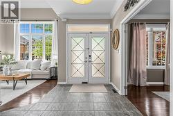 Entry foyer featuring patterned glass double doors and gray tile flooring - 