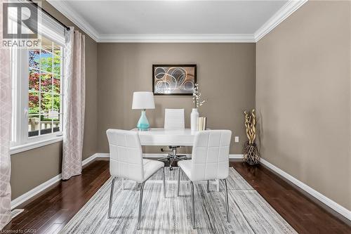 Versatile room featuring dark wood-finish flooring, neutral wall tones, and white crown molding - 729 Boughton Crescent, Milton, ON 