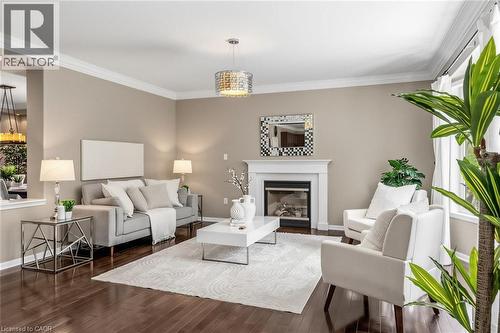 Living area featuring rich wood-finish flooring, a white mantel fireplace, and crown molding - 729 Boughton Crescent, Milton, ON 