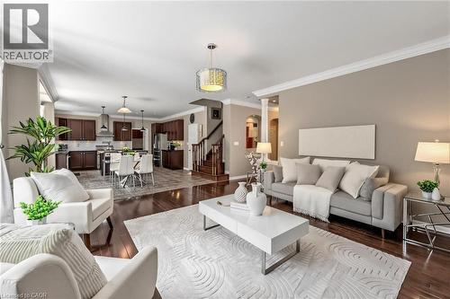 Expansive open-concept living space featuring wood-finish flooring, crown molding, and recessed lighting - 729 Boughton Crescent, Milton, ON 