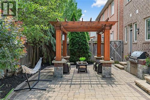 Expansive paver patio featuring a wood pergola and a built-in outdoor grill station - 729 Boughton Crescent, Milton, ON 
