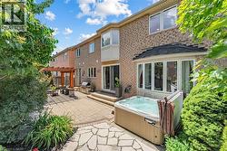 Brick exterior featuring a private hot tub, paver patio, stone patio, and a pergola-covered outdoor dining area - 