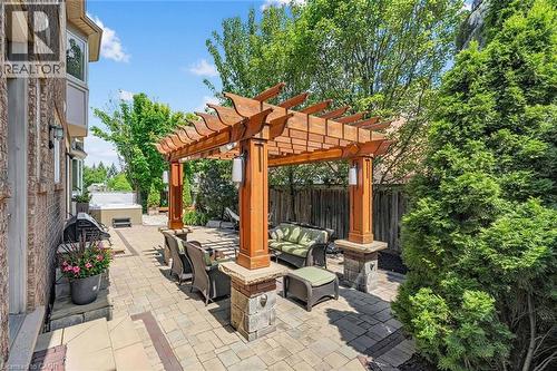 Expansive paver patio featuring a custom wood pergola with integrated lighting - 729 Boughton Crescent, Milton, ON 