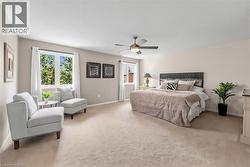 Spacious bedroom featuring light-colored carpet flooring and neutral wall tones - 